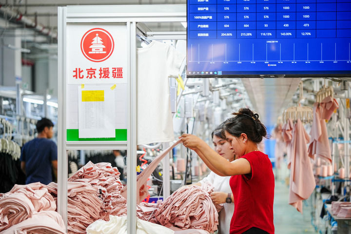 2025年6月27日，在新疆和田市产业园区新疆纱纤亿产业互联网有限公司车间内，工人在整理布料。新华社记者 徐宏岩 摄