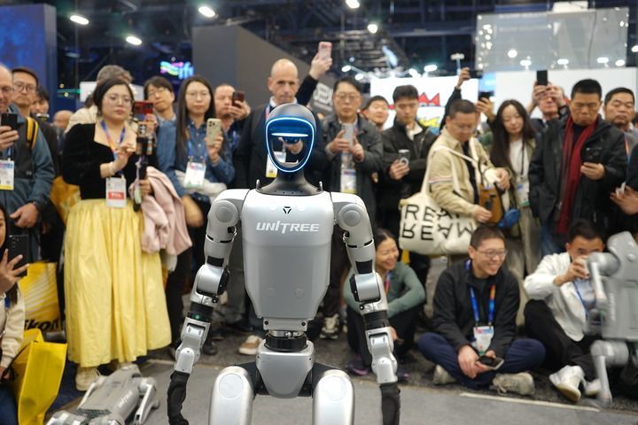 2025年1月8日，在美国拉斯维加斯消费电子展上，人们在宇树科技展区观看机器人展示。新华社发（曾慧摄）