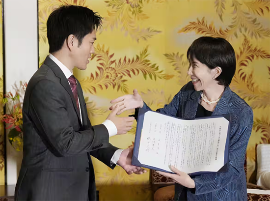 10月20日,高市早苗在签署后与吉村洋文握手 时事通讯社