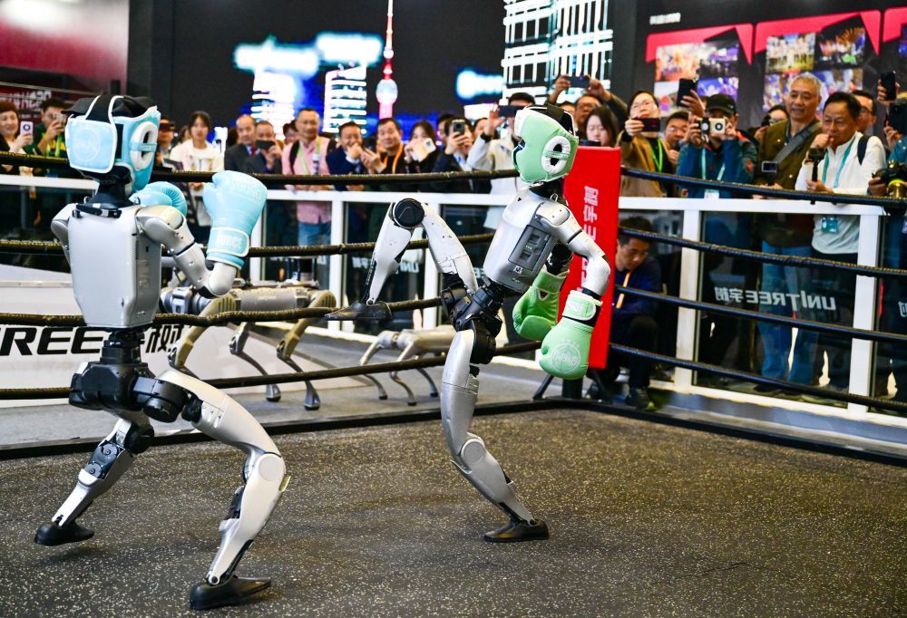 2025年11月6日,人形机器人在第八届进博会宇树科技展台进行格斗表演。当日,在技术装备展区宇树科技展台,两台G1人形机器人的格斗表演吸引了众多观众。它们戴着护具及拳套,施展直拳、勾拳、左右鞭腿,展示倒地自主起身等复杂动作,不时赢得观众喝彩。