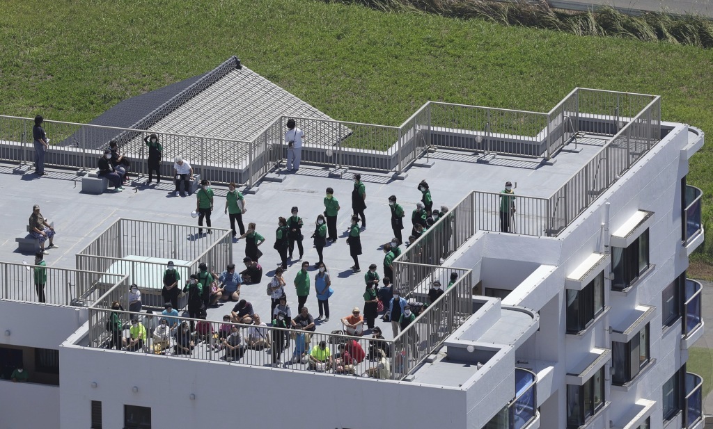 7月30日,日本千叶县,海啸预警发布后,沿海居民在屋顶避难。