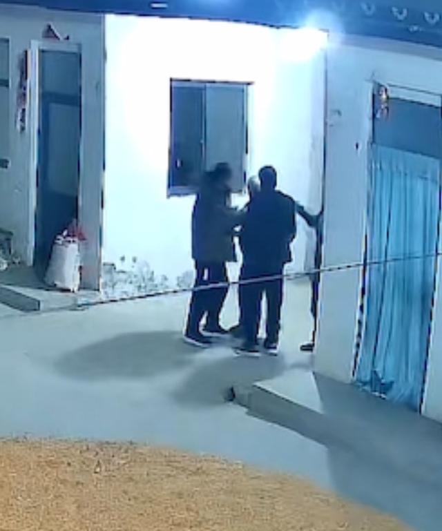 视频中三名男子将老人围在中间。(来源/截图)