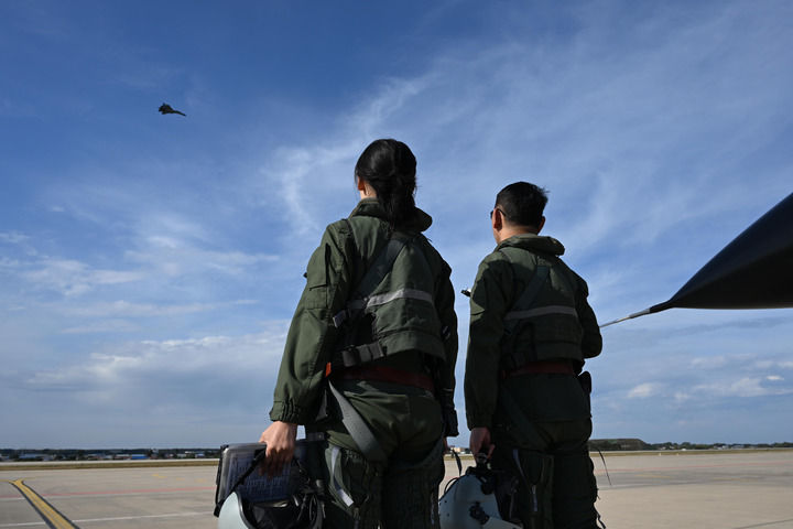 9月20日,第十一届空军航空开放活动和长春航空展上,2名歼-11BS飞行员观看战友飞行展示。新华社发(余红春 摄)