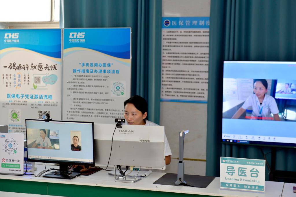 在山东省郓城县随官屯镇卫生院医保便民服务站,工作人员在开展“手机视频办医保”业务。新华社记者 郭绪雷 摄
