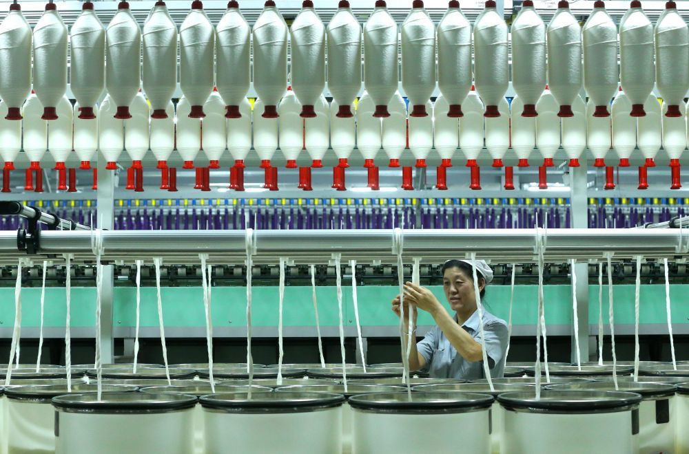 8月22日，山东省青岛市即墨区龙山街道一家科技纺织企业的工人在智慧纺纱生产线上生产高端纤维。新华社发（梁孝鹏摄）