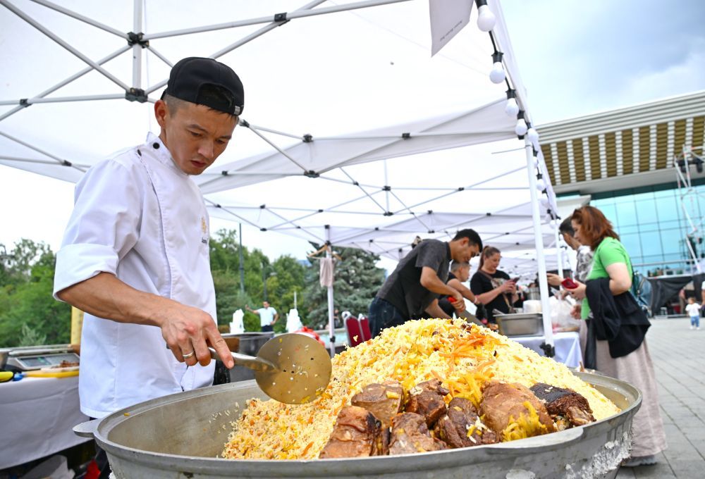 2024年8月24日，在哈萨克斯坦阿拉木图美食节上，厨师制作手抓饭。新华社发（阿拉木图市旅游局供图）