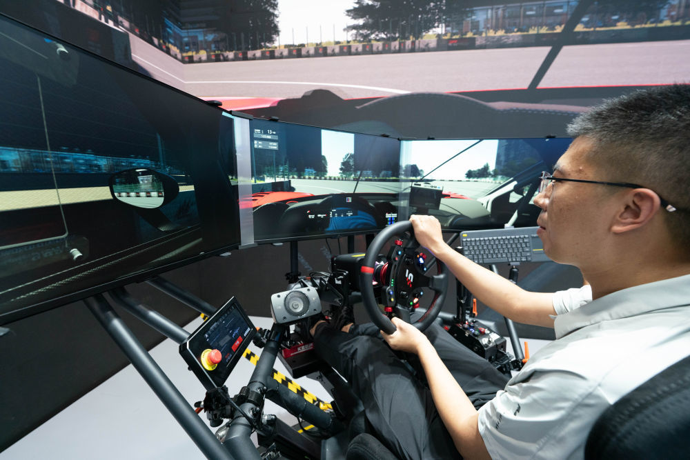 ↑ 9月11日，参观者在体验六自由度赛车模拟器。