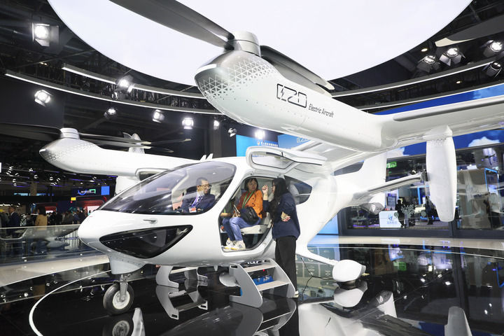 2025年11月8日,人们在第八届进博会汽车及智慧出行展区时的科技展位体验电动垂直起降飞行器。新华社记者 王翔 摄