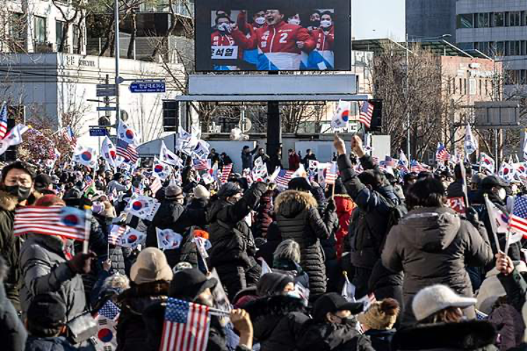 当地时间2025年1月2日,韩国首尔总统官邸附近举行支持尹锡悦的集会,屏幕上显示着他的照片。图片来源:视觉中国