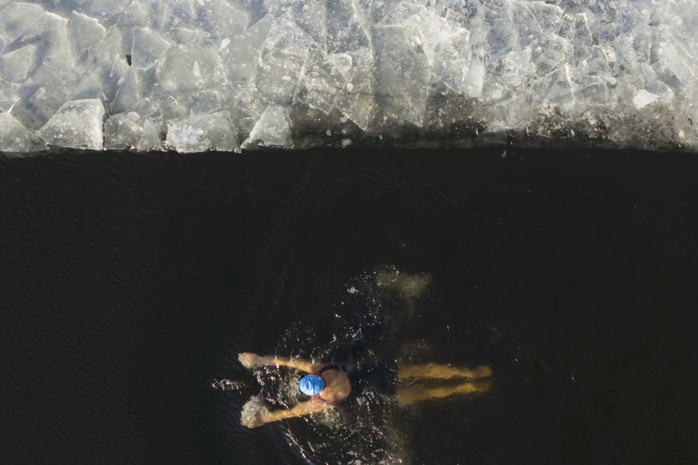 ↑2025年12月12日，冬泳爱好者在哈尔滨中东铁路公园冬泳场游泳（无人机照片）。