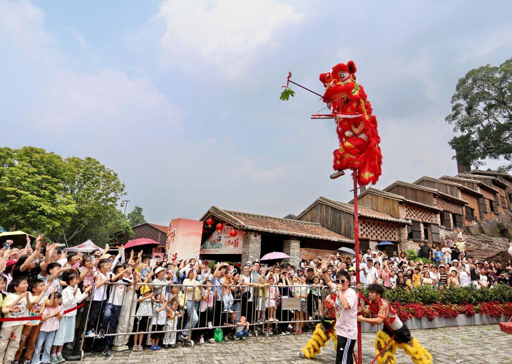 5月2日,在广东省佛山市禅城区南风古灶旅游休闲街区,游客在观看醒狮表演。新华社发(黄继明 摄)