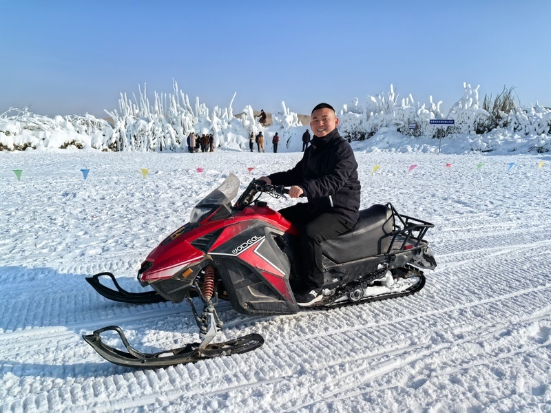 游客在和田县昆仑山七星滑雪场体验雪地摩托 （央广网记者丁安 摄）