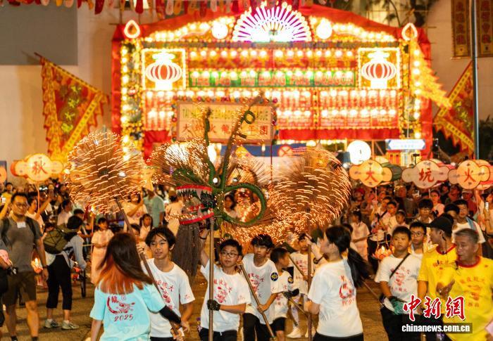 10月5日晚,香港“大坑舞火龙”再度于铜锣湾大坑的大街小巷上演。“大坑舞火龙”2011年被列入国家级非物质文化遗产代表性项目名录,是香港庆祝中秋节的重要节庆盛事活动。图为少年儿童用发光二极管(LED)制成的“小火龙”进行表演。 中新社记者 侯宇 摄