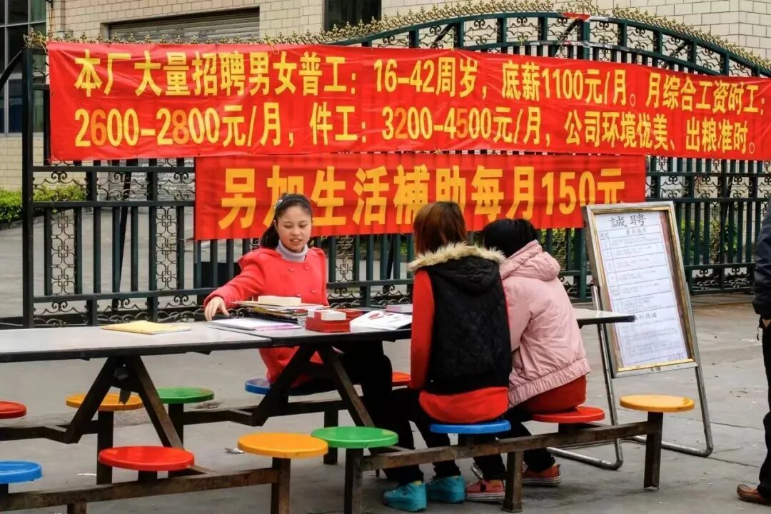 工厂的大门外摆着招聘摊儿,招聘就在厂门口直接进行。