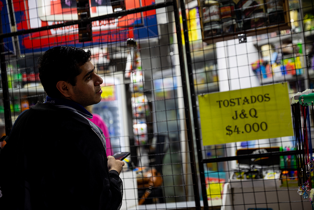 2025年10月24日,阿根廷布宜诺斯艾利斯,一名男子在一家商店前排队购物,此前阿根廷面临美元储备不足的严峻局面。