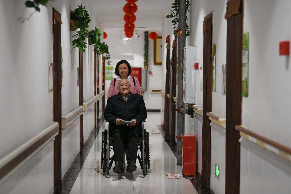 ↑在四川省南充市五福堂颐养院，刘寿山的儿媳刘革玲陪他去练书法（4月9日摄）。