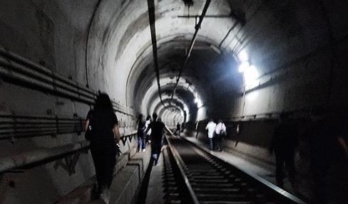 ▲乘客通过地铁隧道撤离