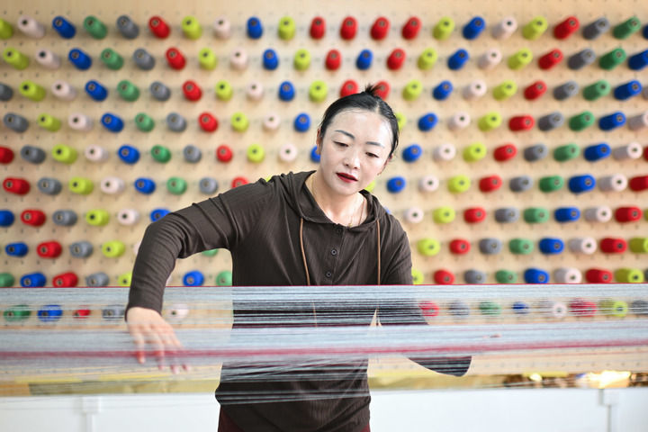 在青海省果洛藏族自治州玛沁县久美家园的“沪沁怡”氆氇手工编织坊内，工作人员卓玛杰在梳经，该工坊由上海援青团队打造（2024年7月19日摄）。新华社记者 张龙 摄