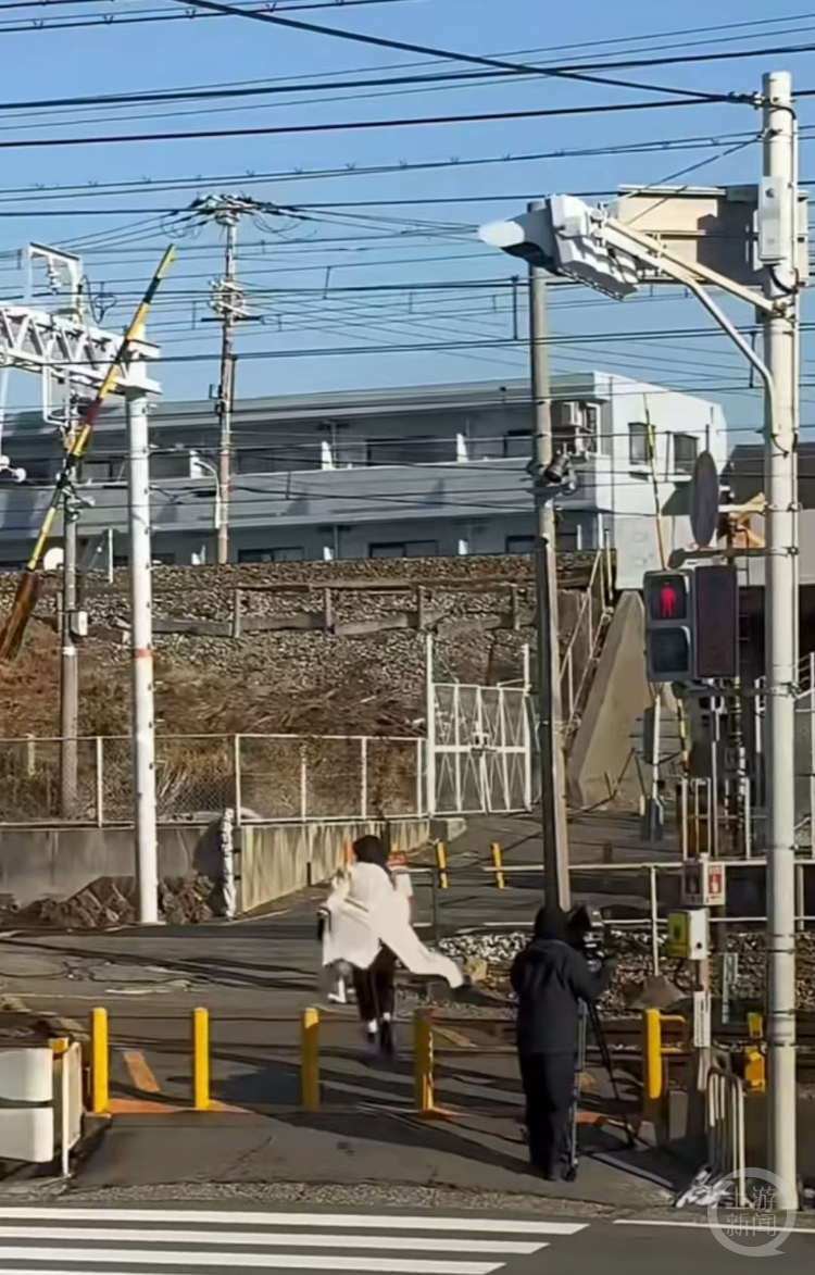 日本记者在现场测试小跑穿越道口所需时间。视频截图