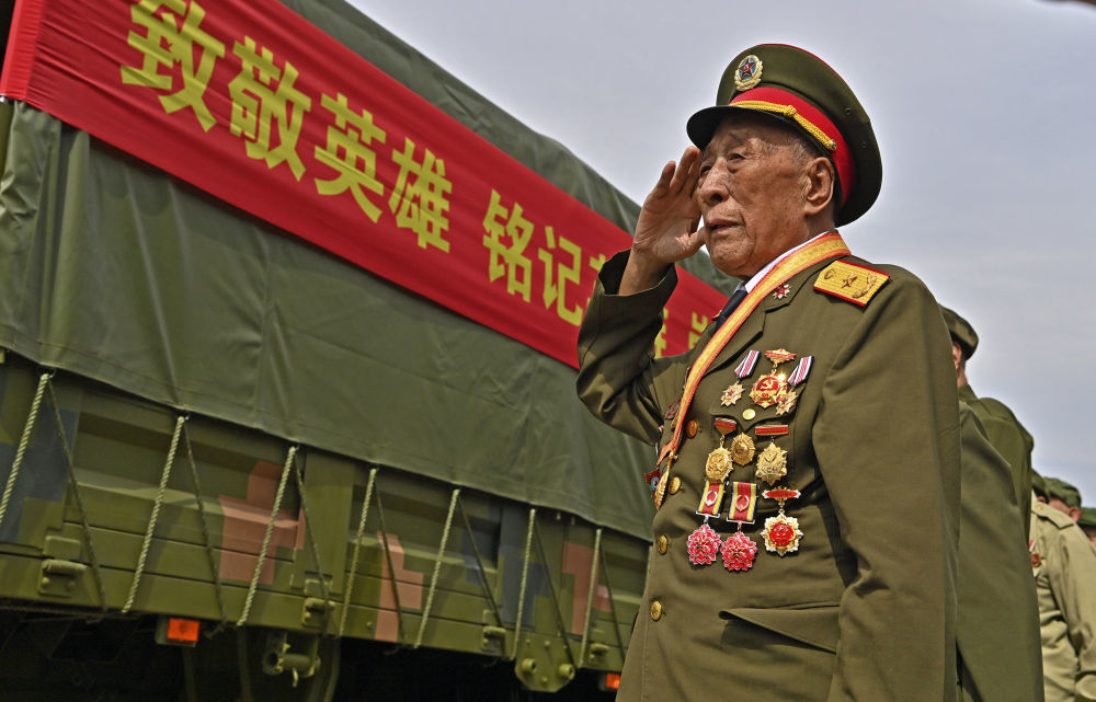 9月12日,志愿军老战士在沈阳抗美援朝烈士陵园门口迎接运送志愿军烈士遗骸的车队。新华社记者 周华 摄