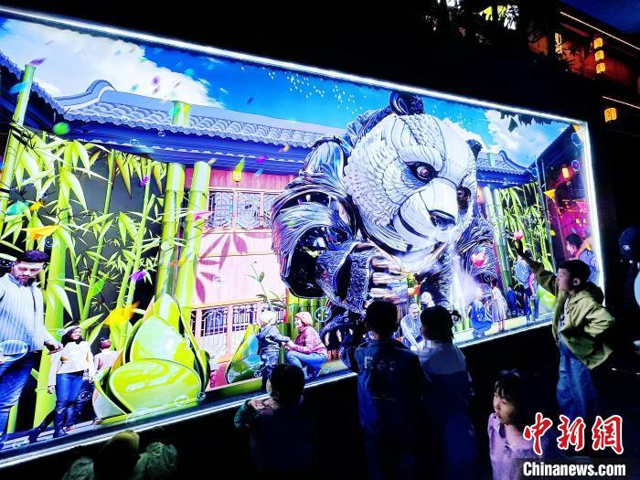 图为4月25日，孩童们围观在熊猫海报电子显示屏前。高展　摄