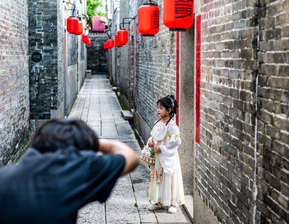 9月13日,摄影师在塱头村积墨楼为孩子拍摄古风写真。