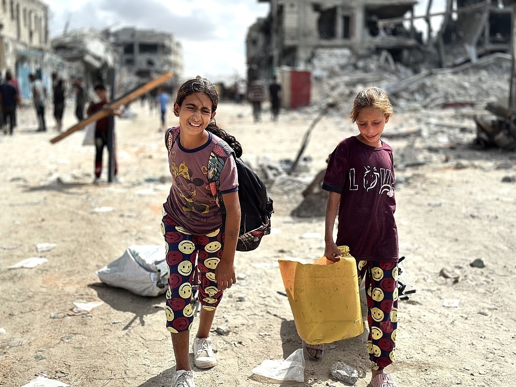 当地时间2025年10月12日,加沙地带汗尤尼斯,民众在等待救援物资。