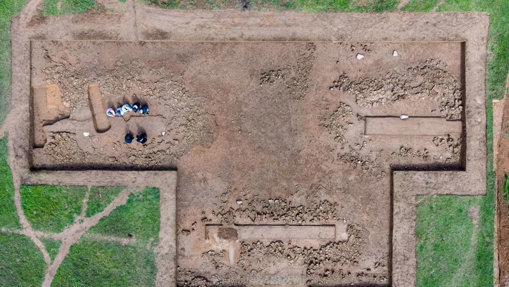 10月15日,在甘肃省陇南市礼县四角坪遗址考古发掘现场,考古工作人员观察一处阙门遗迹(无人机照片)。新华社记者 郎兵兵 摄