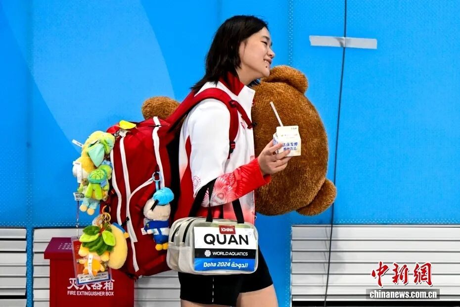11日晚,广东队队员全红婵身背挂满娃娃饰品的书包离开赛场。 中新社记者 陈骥旻 摄