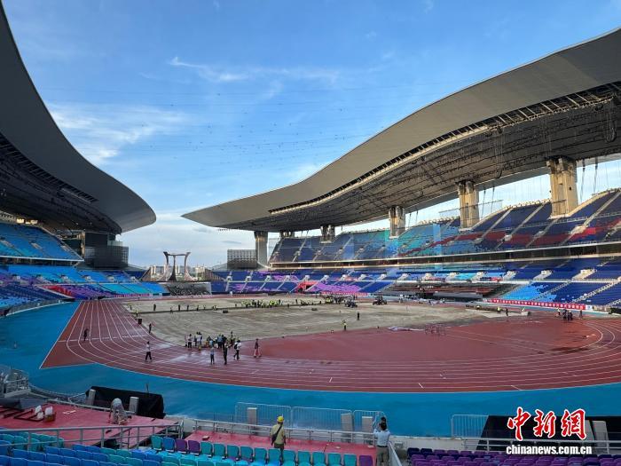 图为工作人员铺设草坪。 记者 何俊杰 摄