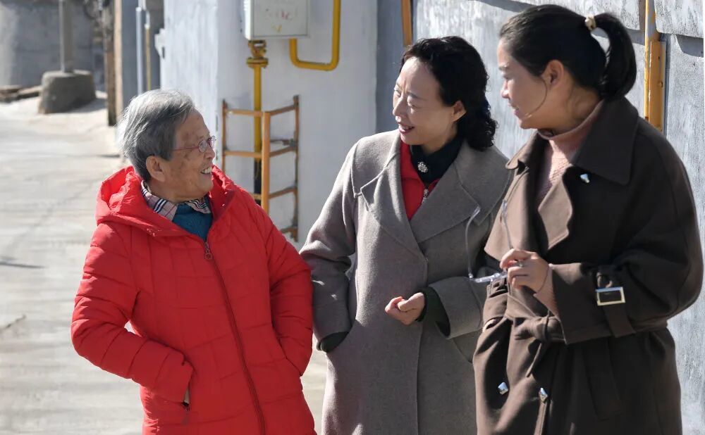 在陕西省榆林市佳县,路生梅与志愿服务机构的工作人员聊天(2022年11月15日摄)。新华社记者 邹竞一 摄