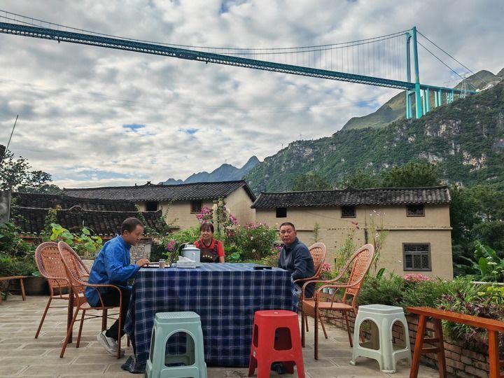 2025年9月27日，在贵州花江峡谷大桥附近，林国权（左）在自家民宿和员工坐在一起交流。新华社记者 向定杰 摄
