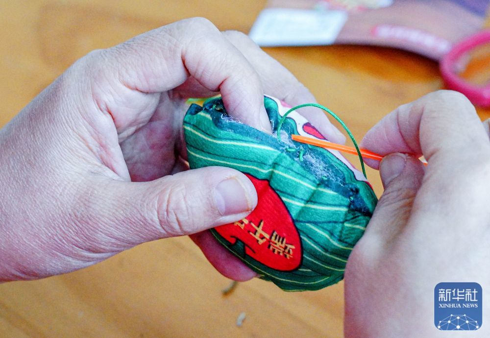 ↑ 5月23日，志愿者在山东省荣成市新时代文明实践中心制作香囊，准备送给孤寡老人。新华社发（李信君摄）