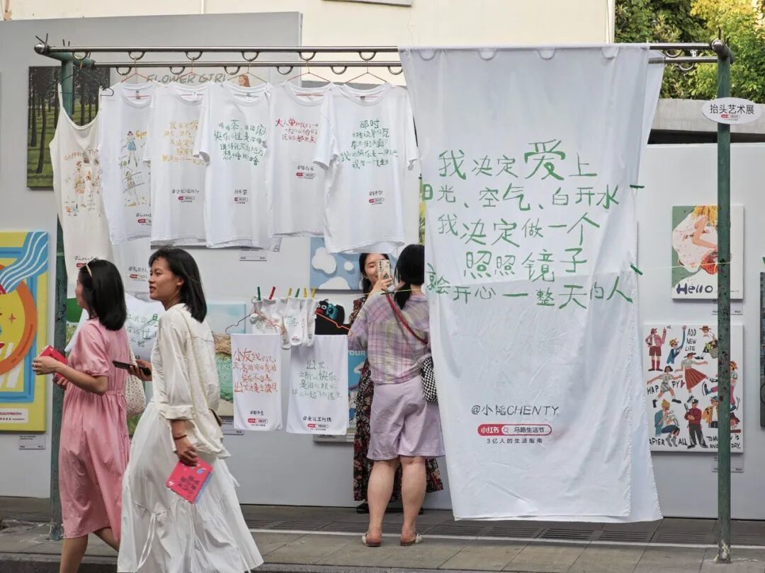 2024年8月24日,上海第二届“小红书马路生活节”,淡水路上的文字艺术装置挂在居民的晾衣竿上,构成了独特的“抬头艺术展”。(图/CFP)