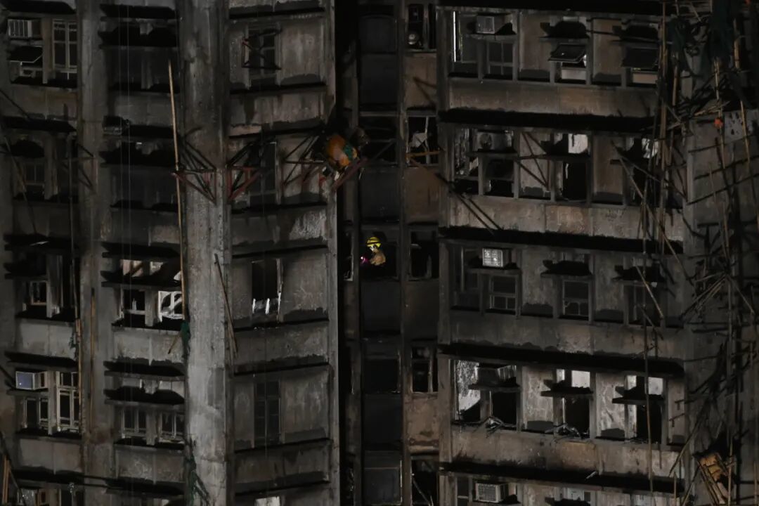 消防员在宏福苑其中一座楼内进行搜救行动。图源/中新