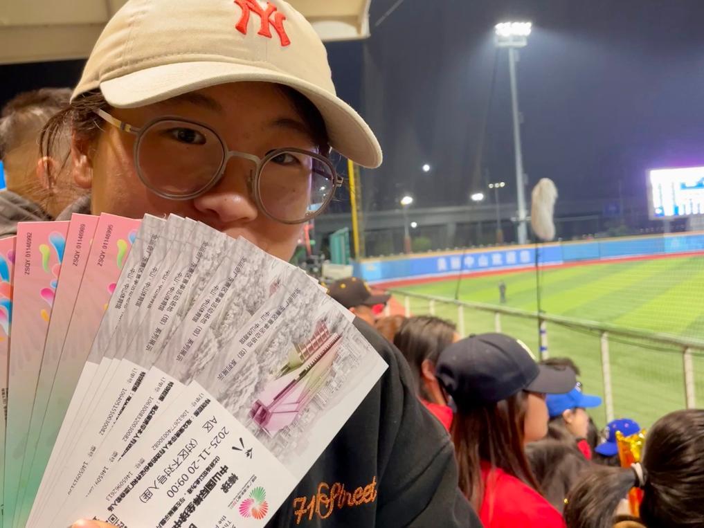 11月20日，一名观众在全运会棒球比赛现场展示自己的票根。新华社记者霍思颖 摄