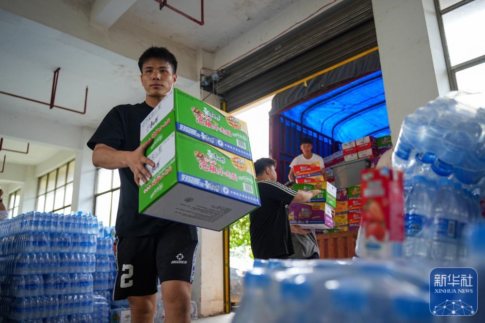 6月25日，林进标在贵州省榕江县工业园区内搬运救援物资。