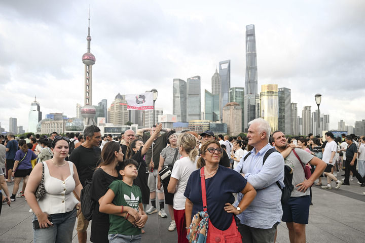 2025年7月21日，意大利游客在上海外滩听导游介绍景点。新华社记者 陈浩明 摄