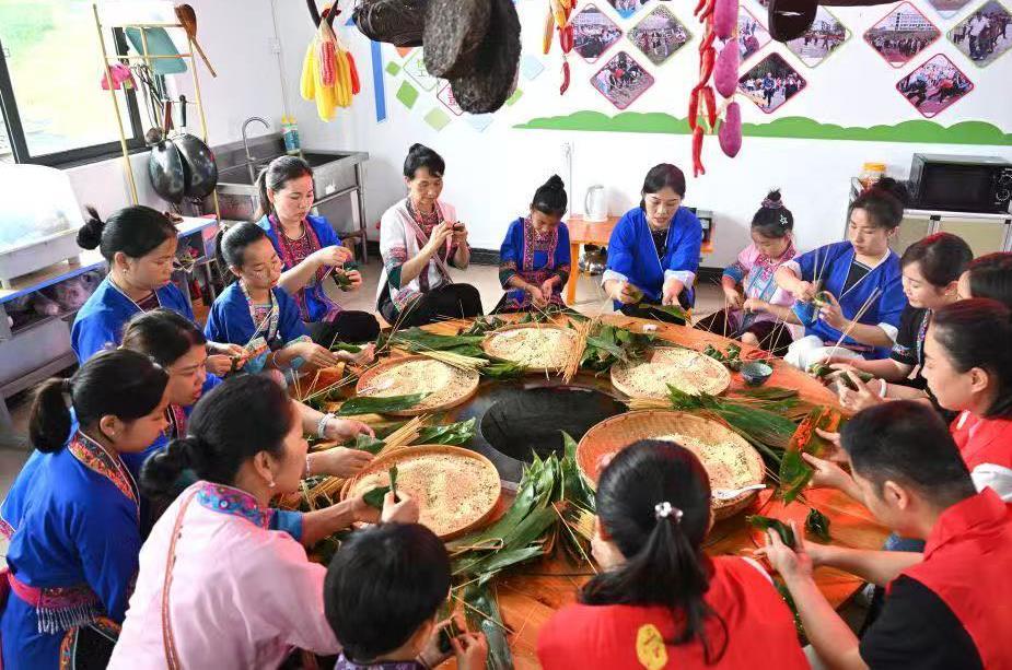 △2025年5月23日，广西柳州市三江侗族自治县，孩子和家长一起学习制作三江粽。