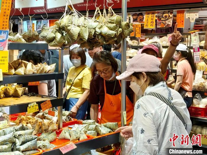 5月30日，台湾迎来端午节连假，各大市场粽香四溢，民众纷纷前往选购粽子等节庆美食。图为台北南门市场，民众排队选购粽子。 中新社记者 张晓曦 摄