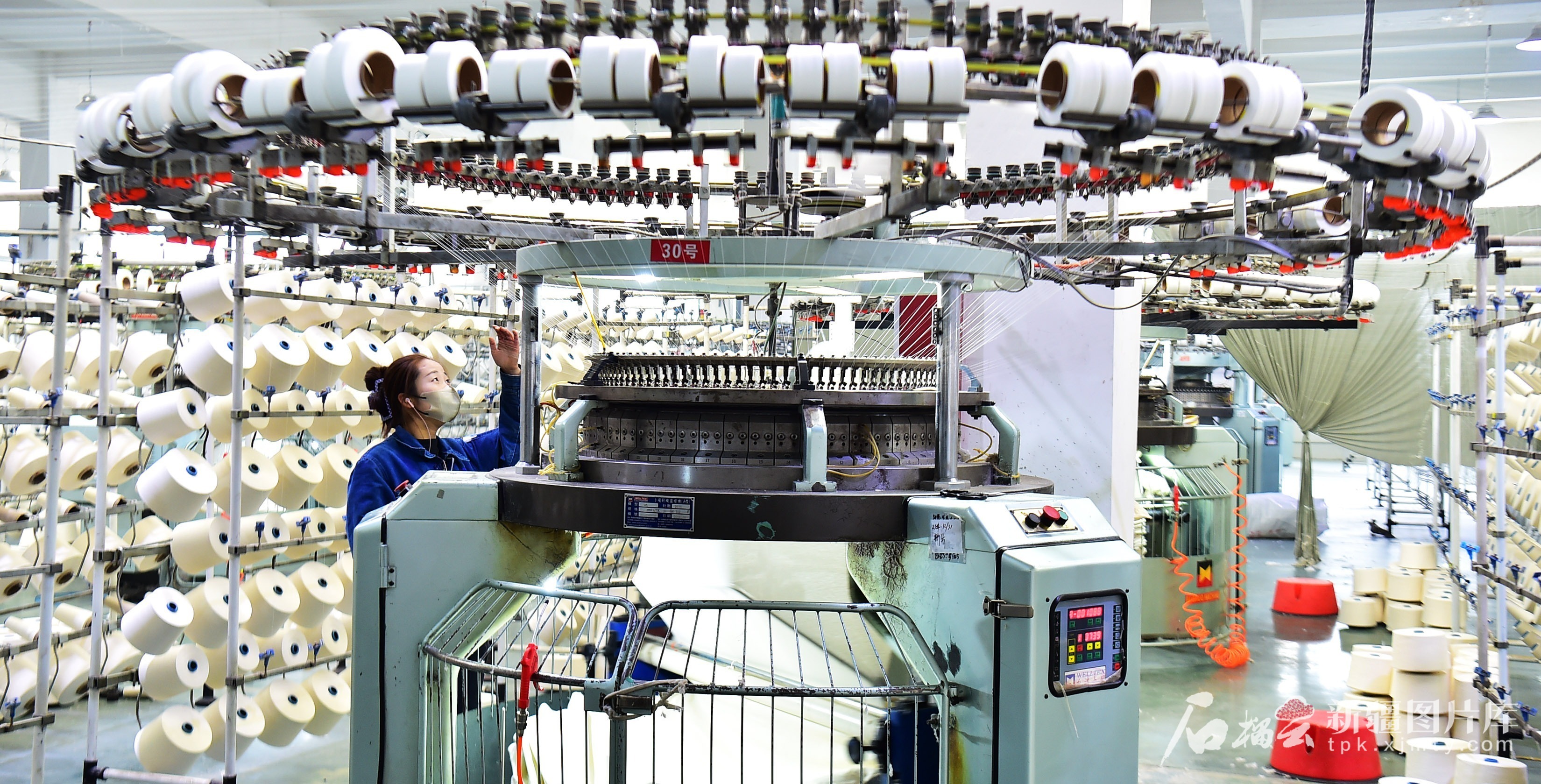 4月29日，在位于阿克苏阿拉尔高新区的阿拉尔市兴美达印染有限公司生产车间，工人正在自动化生产线上监控纺纱质量。 王拓摄