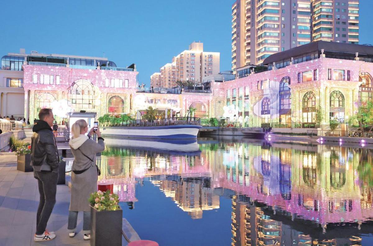 2024年10月19日，亮马河铂宫船闸，游客正在拍摄灯光秀。新京报记者王飞摄