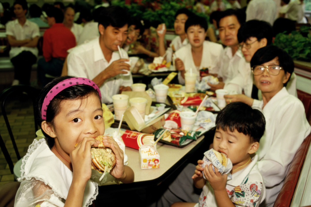 〓 1993年7月,广东深圳,家长们带着孩子在麦当劳吃汉堡。