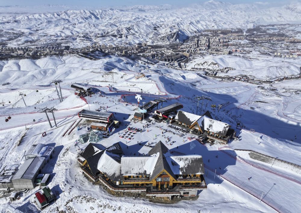 这是1月24日拍摄的将军山国际滑雪度假区山顶区域与阿勒泰市城区风貌（无人机照片）。