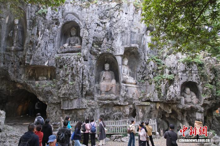 12月1日，游客参观飞来峰造像。中新社记者　曹丹　摄