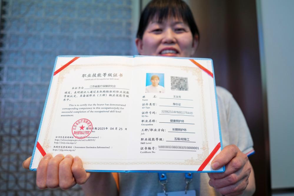 4月28日，王汝芳在首批长期照护师职业技能等级证书颁发活动上展示自己的“000001”编号证书。新华社记者 李博 摄