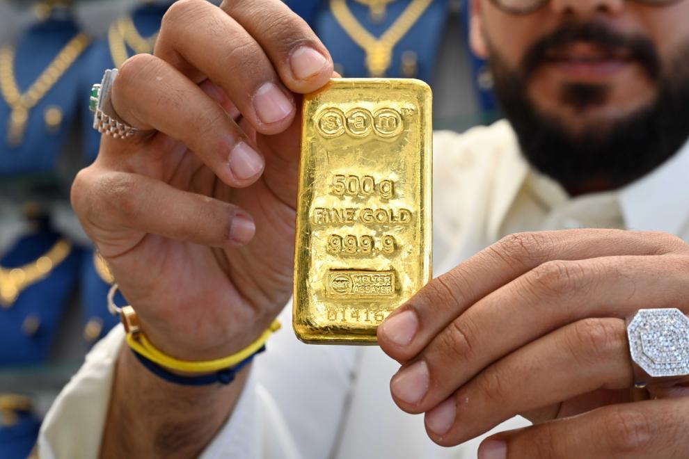 10月23日,在科威特首都科威特城,一名男子在金店内展示500克的金条。新华社发(阿萨德摄)