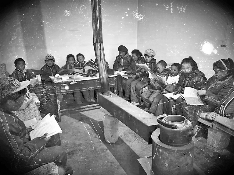 上世纪80年代，那曲县（色尼区）完全小学学生围坐在火炉旁上课。那曲市色尼区委宣传部提供