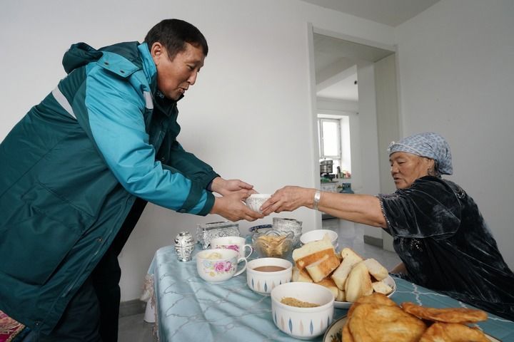 木哈买提别克·木哈买提哈力在曾经帮助过的牧民家中喝奶茶（1月4日摄）。新华每日电讯记者 阿曼 摄