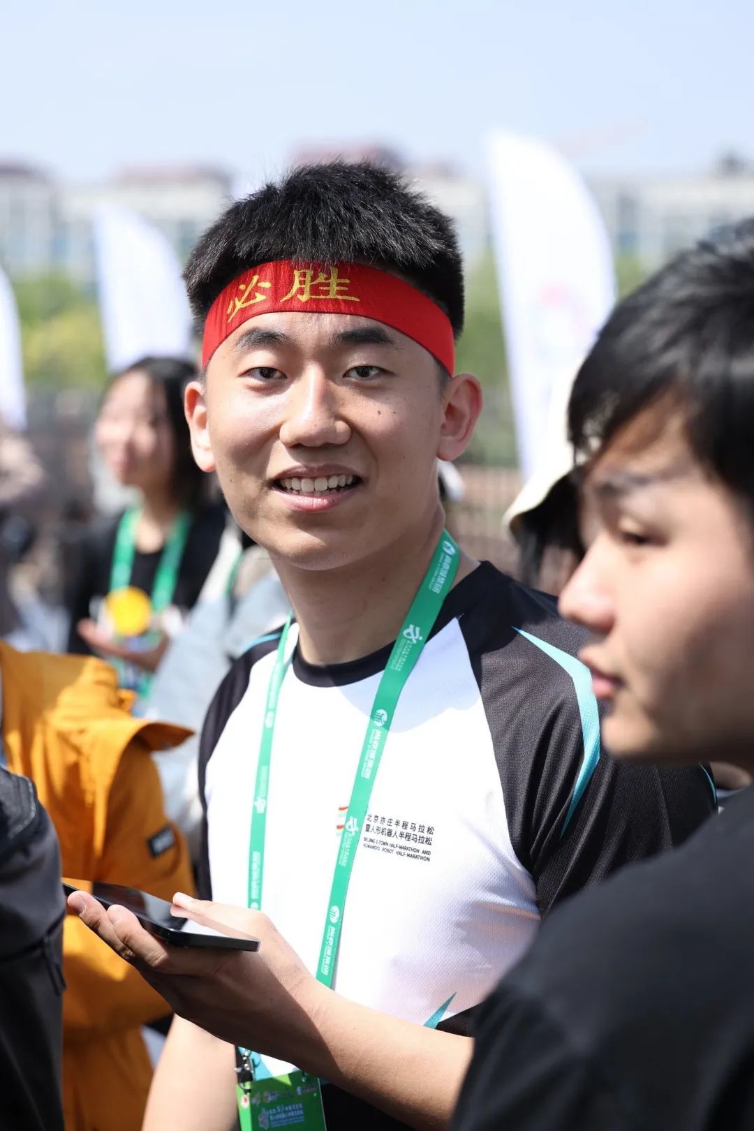 ▲马拉松比赛当日,姜哲源在赛场外等待N2冲线。 企业供图